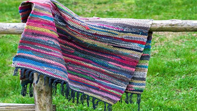 Traditional handmade rug hanging on the wooden fence